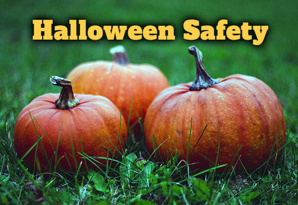 Three pumpkins sitting on the grass with the text Halloween Safety.