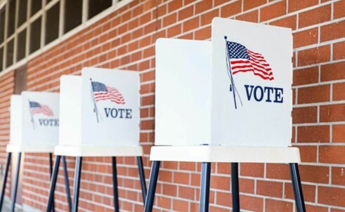 Voting stations against a brick wall.